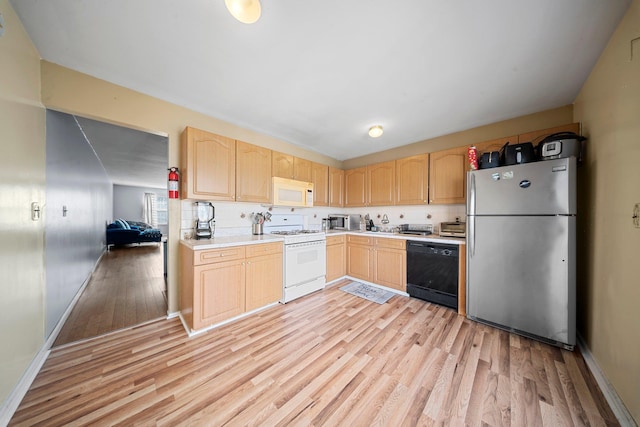 kitchen featuring stainless steel appliances, light countertops, light wood-style flooring, and light brown cabinetry