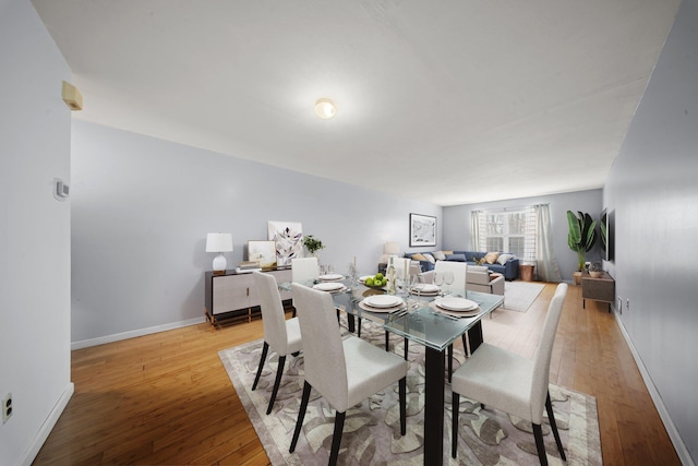 dining space with baseboards and light wood finished floors