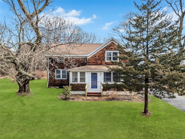 shingle-style home with entry steps and a front yard