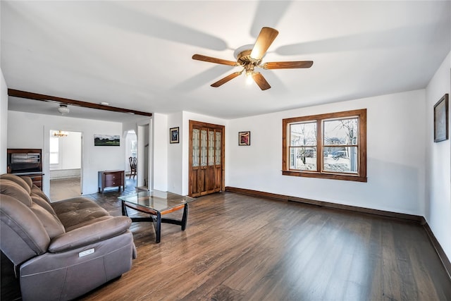 living room with ceiling fan with notable chandelier, dark wood finished floors, and baseboards