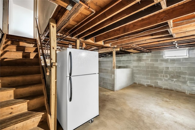 basement with stairway and freestanding refrigerator