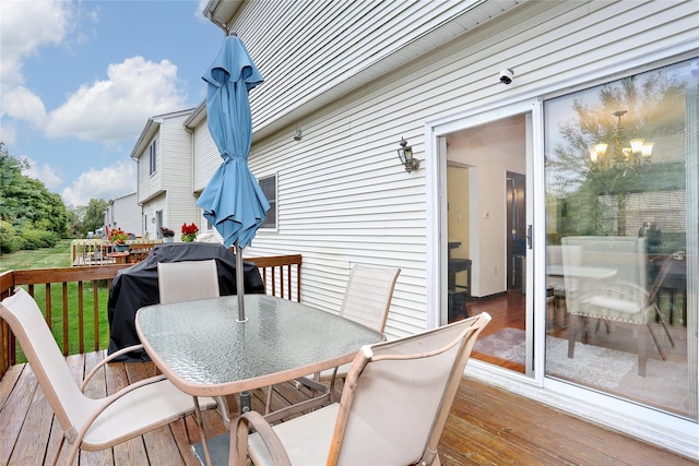 wooden deck featuring outdoor dining area and a yard