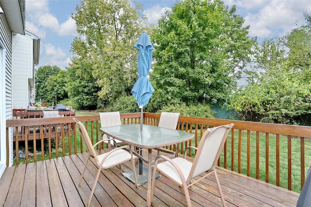 deck featuring outdoor dining area and a yard