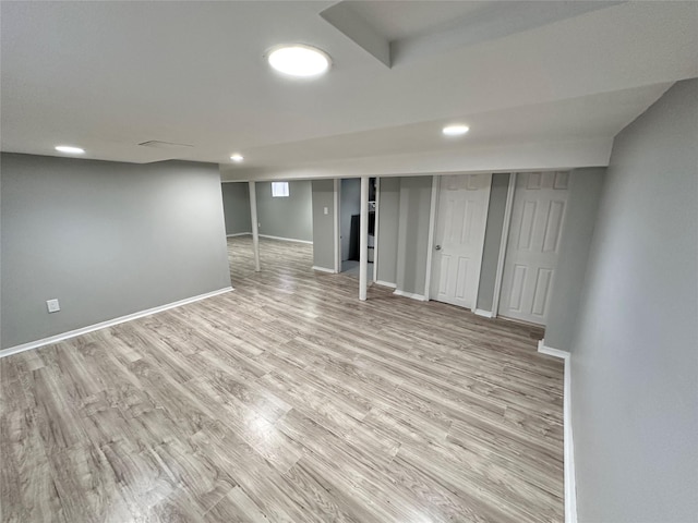 finished basement featuring recessed lighting, light wood-style flooring, and baseboards