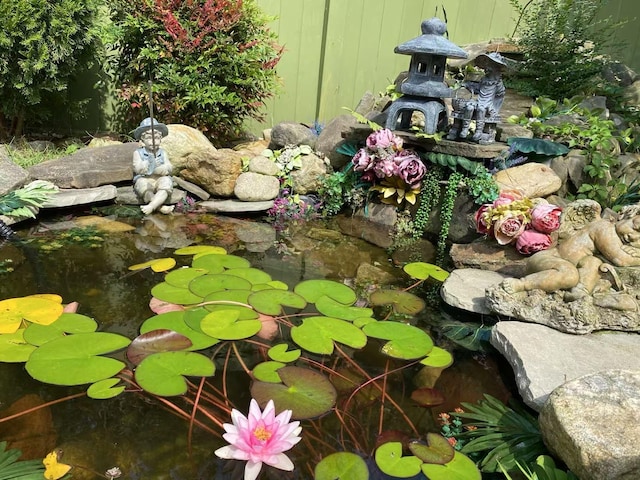 exterior details featuring a garden pond and fence