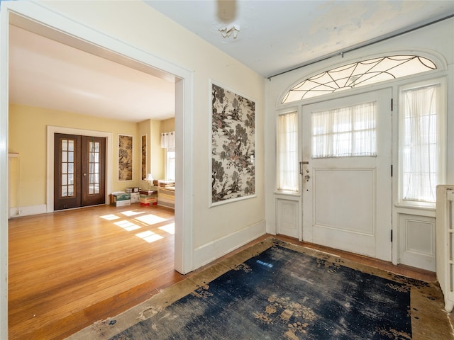 entrance foyer featuring wood finished floors, french doors, and baseboards