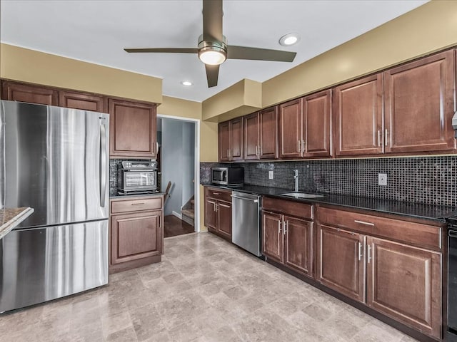 kitchen with a sink, stainless steel appliances, tasteful backsplash, and dark countertops