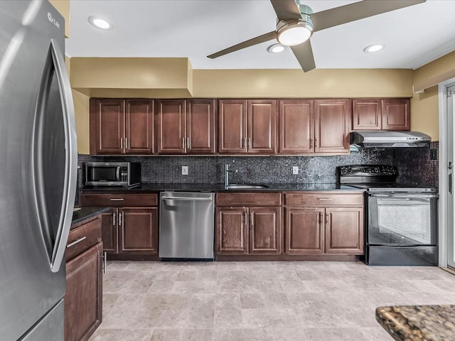 kitchen featuring under cabinet range hood, stainless steel appliances, tasteful backsplash, and a sink