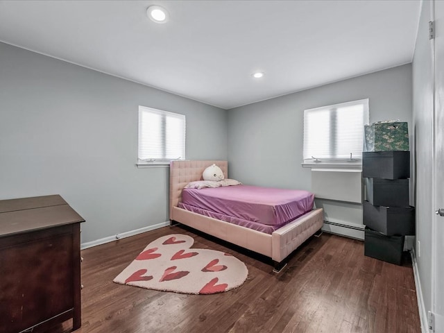 bedroom featuring recessed lighting, a baseboard heating unit, baseboards, and wood finished floors