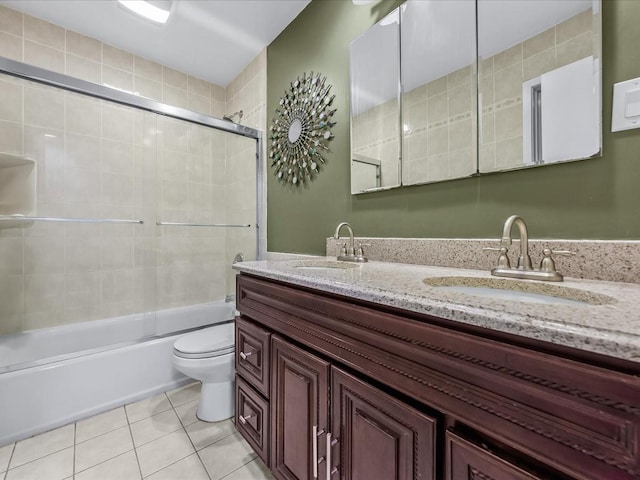 full bathroom featuring a sink, bath / shower combo with glass door, toilet, and tile patterned floors