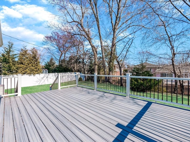 wooden deck with a lawn and fence