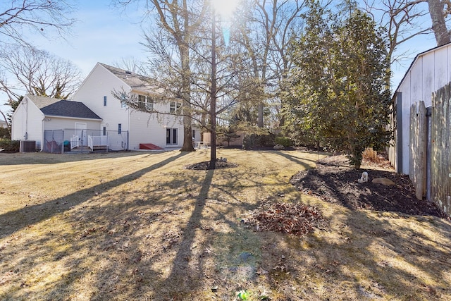 view of yard with central AC and fence