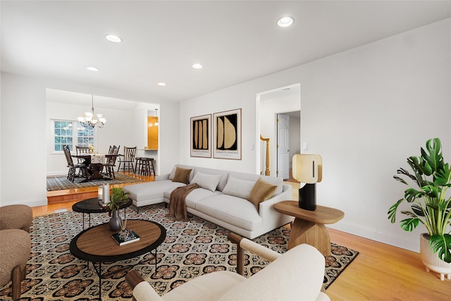 living room featuring recessed lighting, light wood-type flooring, baseboards, and an inviting chandelier