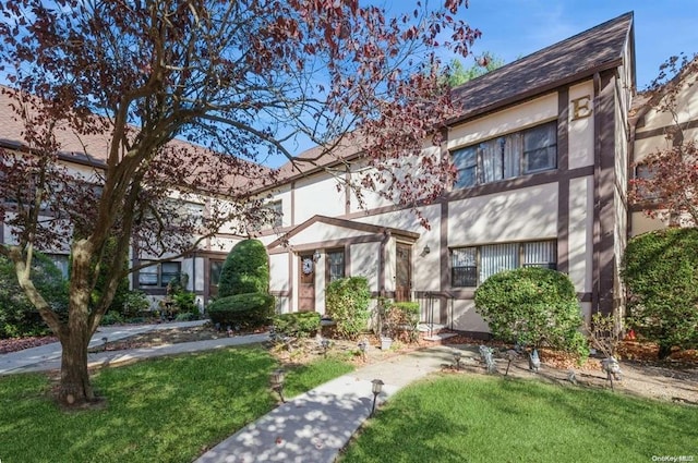 view of front of house with a front lawn and stucco siding