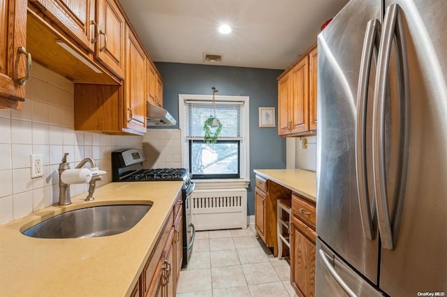 kitchen with visible vents, brown cabinets, under cabinet range hood, a sink, and stainless steel appliances