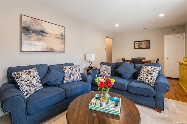 living area with visible vents, recessed lighting, and wood finished floors