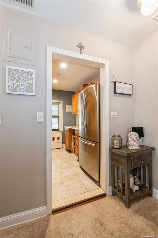 kitchen featuring visible vents, light carpet, freestanding refrigerator, light countertops, and baseboards