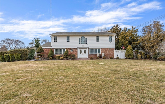 view of front of home featuring brick siding, a front yard, and fence