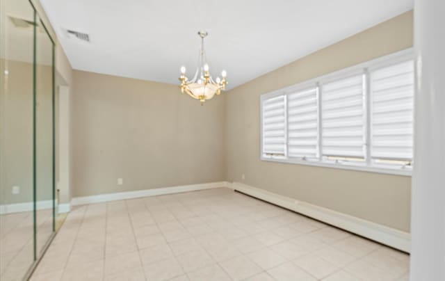 unfurnished room with baseboards, baseboard heating, visible vents, and an inviting chandelier