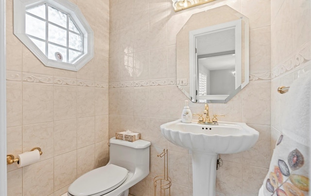 bathroom featuring toilet and tile walls