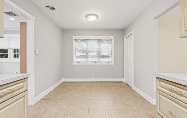 unfurnished dining area featuring visible vents, baseboards, and light tile patterned flooring