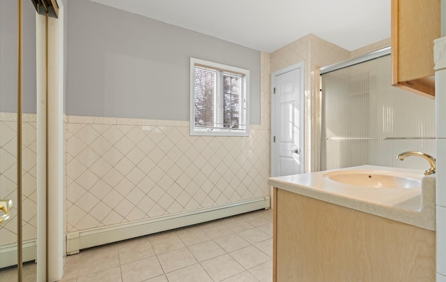 bathroom featuring a wainscoted wall, tile patterned floors, an enclosed shower, vanity, and tile walls