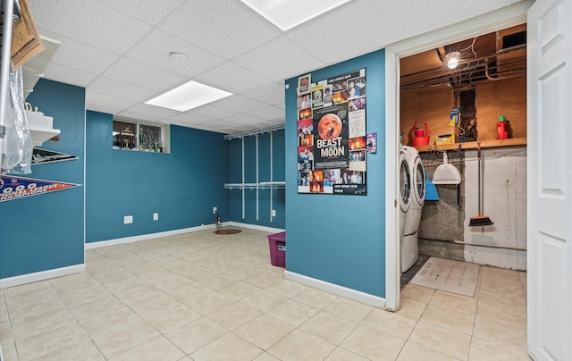 finished basement featuring washing machine and dryer, tile patterned flooring, a drop ceiling, and baseboards