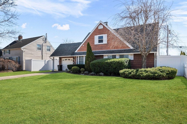 view of front of home featuring driveway, a front lawn, a garage, and fence