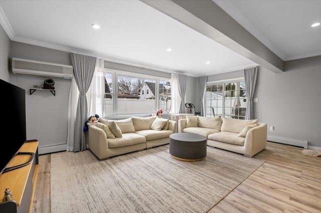 living area with light wood finished floors, a baseboard heating unit, crown molding, baseboards, and a wall mounted air conditioner