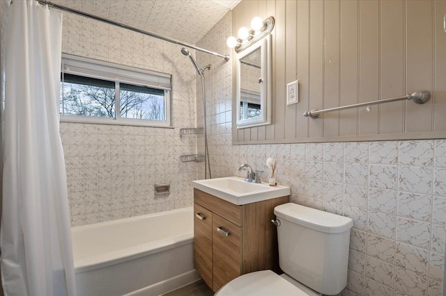 bathroom featuring shower / bathtub combination with curtain, toilet, tile walls, and vanity