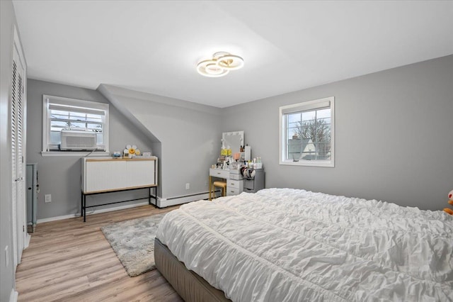 bedroom featuring cooling unit, wood finished floors, baseboards, and baseboard heating