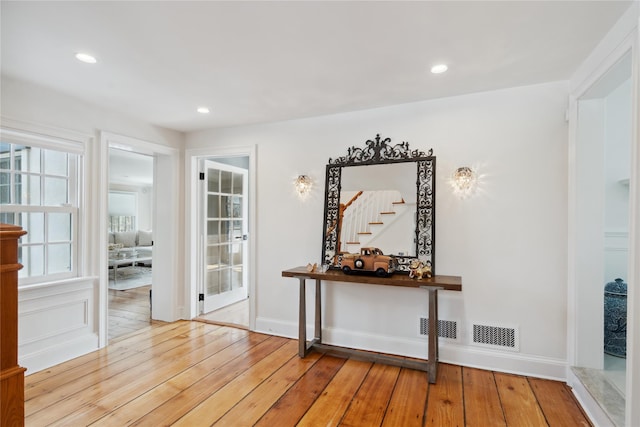 interior space featuring visible vents, baseboards, stairway, recessed lighting, and wood-type flooring