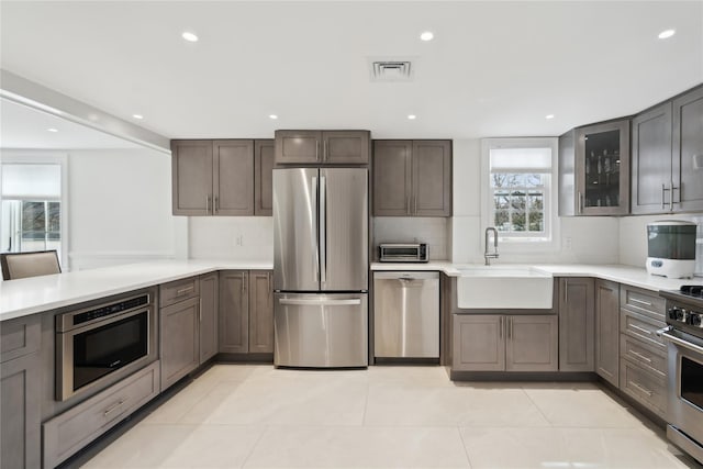 kitchen with a sink, visible vents, backsplash, and appliances with stainless steel finishes