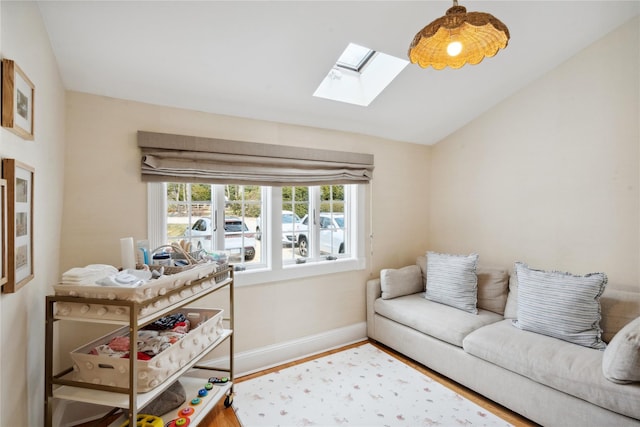 living room featuring baseboards, vaulted ceiling with skylight, and wood finished floors