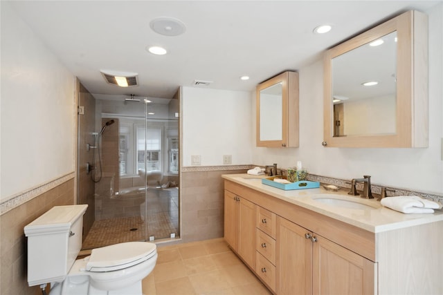 full bath featuring a sink, visible vents, toilet, and tile walls