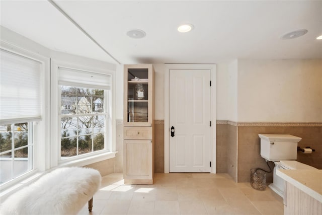 bathroom with recessed lighting, tile walls, wainscoting, and tile patterned flooring