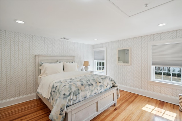 bedroom featuring visible vents, wallpapered walls, recessed lighting, light wood finished floors, and baseboards