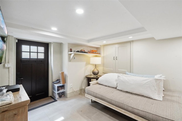 interior space featuring a tray ceiling, recessed lighting, and baseboards