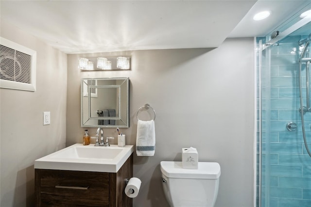 bathroom featuring toilet, vanity, and a tile shower