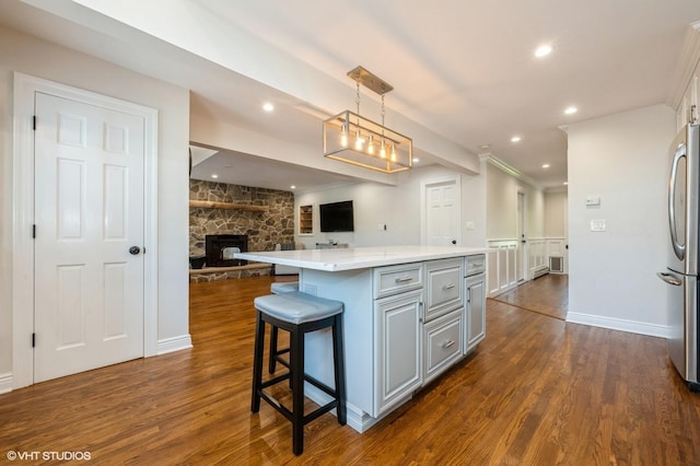 kitchen with freestanding refrigerator, dark wood-style flooring, a kitchen island, open floor plan, and gray cabinets