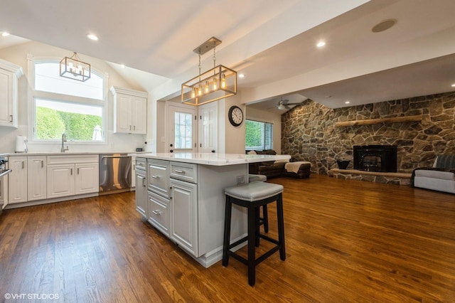 kitchen with lofted ceiling, open floor plan, dark wood-style floors, dishwasher, and gray cabinetry
