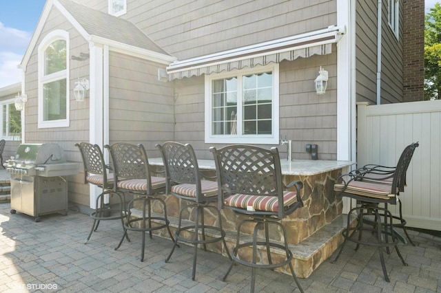 view of patio / terrace featuring grilling area, fence, and outdoor dining space