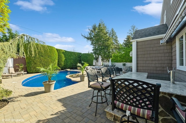 view of swimming pool with a patio, a fenced in pool, outdoor dining space, and a fenced backyard