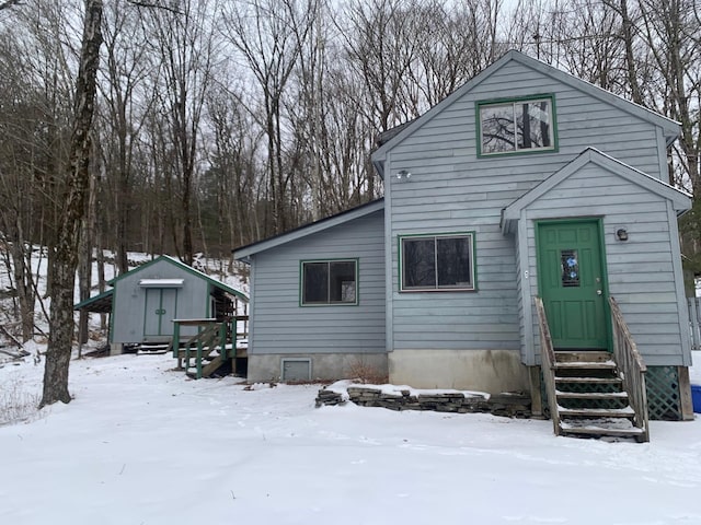 view of front of property with entry steps, an outdoor structure, and a storage unit