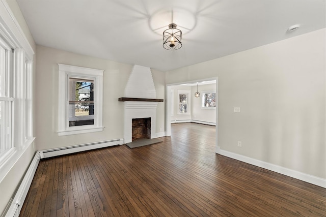 unfurnished living room featuring dark wood finished floors, plenty of natural light, a fireplace, and a baseboard radiator