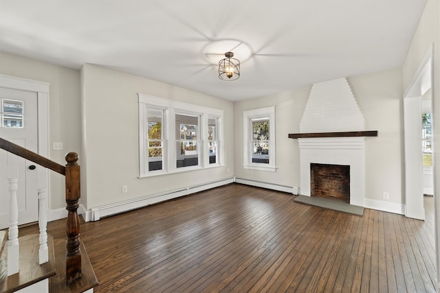 unfurnished living room with baseboard heating, a fireplace, and hardwood / wood-style floors