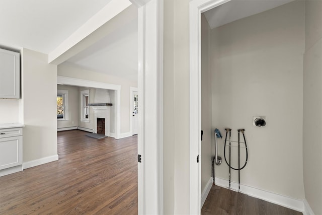 hallway featuring baseboards and dark wood finished floors