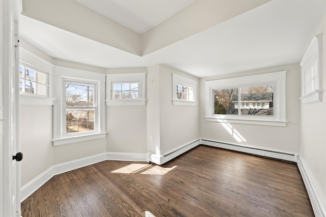 unfurnished room featuring a baseboard heating unit, baseboards, and dark wood-style flooring