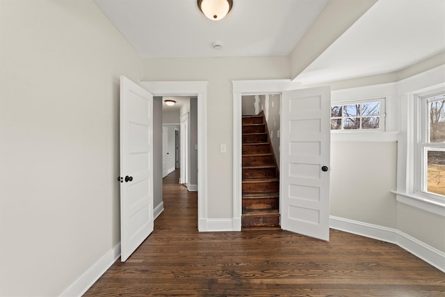 unfurnished bedroom featuring baseboards and dark wood-style flooring