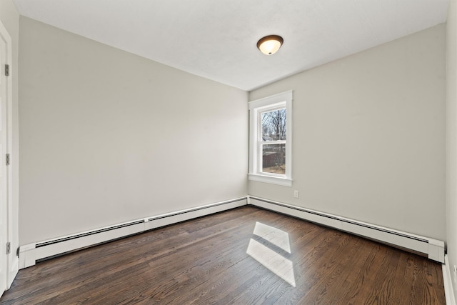 empty room featuring wood finished floors and a baseboard radiator